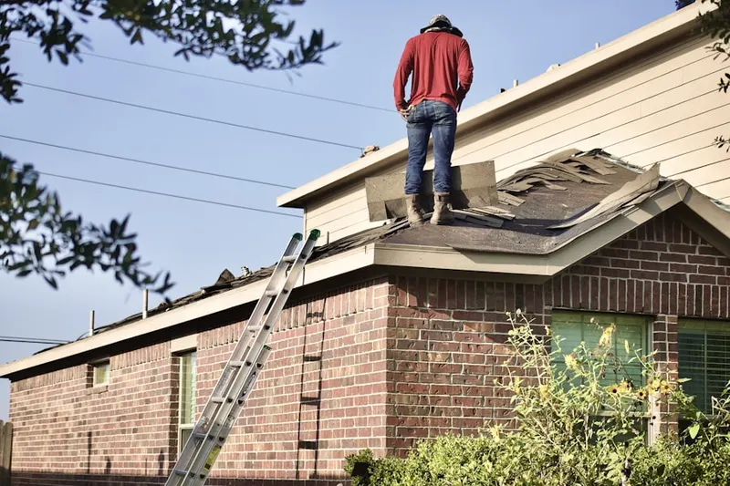 Professional roofer working on a residential roof in Miles